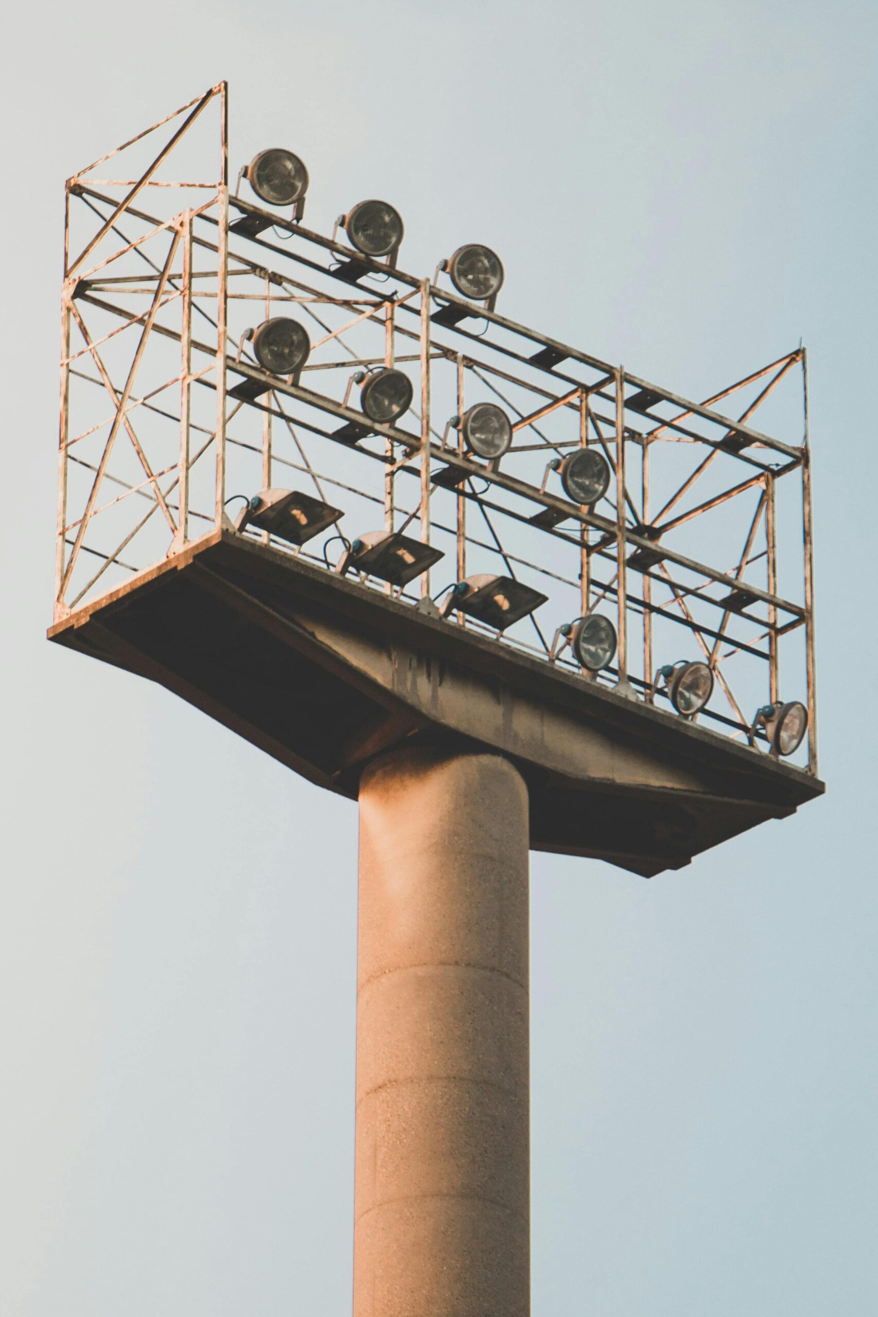 A towering floodlight structure against a pastel sky, ideal for sports or event photography.