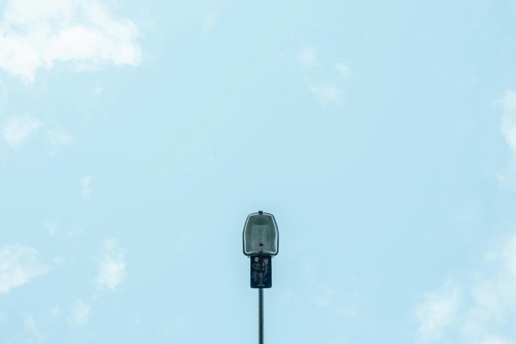 From below modern streetlight located against cloudy blue sky on sunny day in city