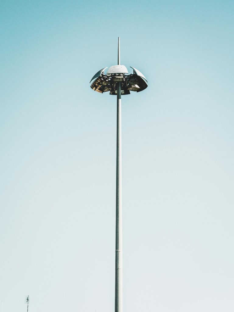 A modern street light with a unique design stands tall against a clear blue sky.